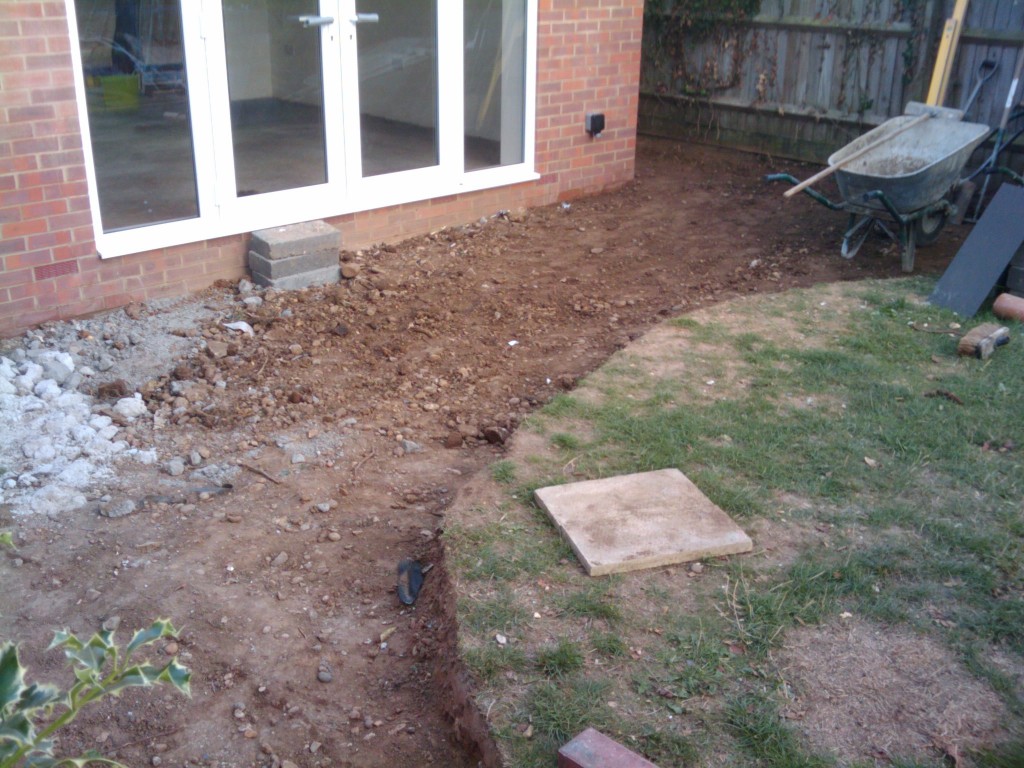 The curve of the patio will be with red bricks, with a light paving stone. It will slope down to the drain
